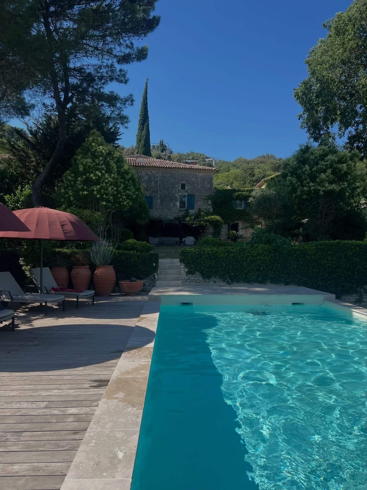 La plage en bois de la piscine et la maison